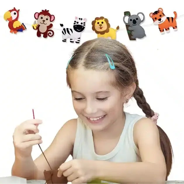 Une fille avec des nattes sourit pendant qu'elle peint, inspirée par les animaux colorés de la jungle sur le mur, parfait pour créer avec le Kit de Couture Enfants - Porte-clés à Faire Soi-Même Sans se piquer le doigt.