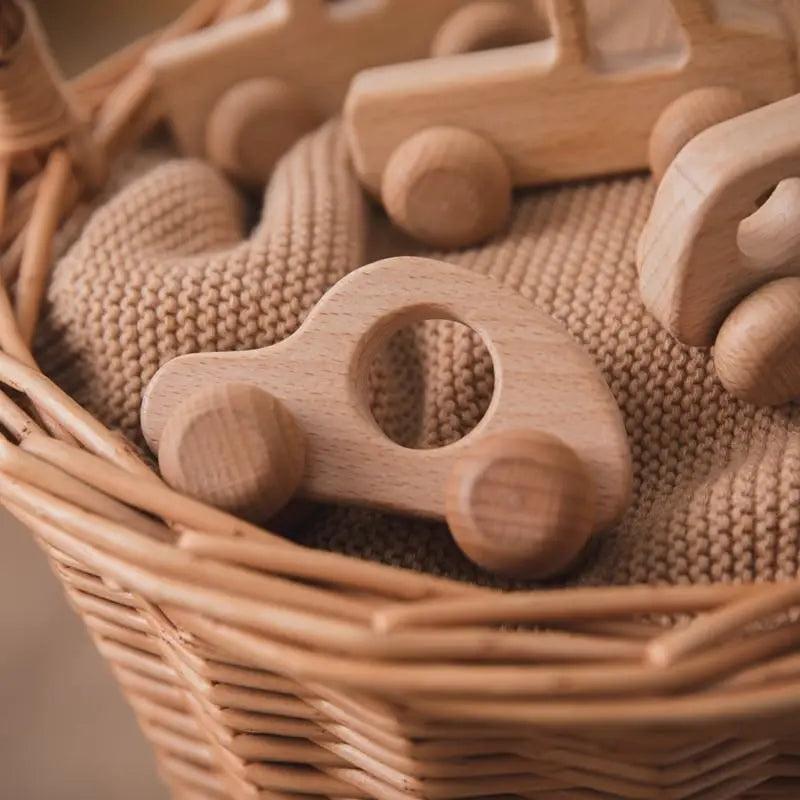 Un panier rempli de petites voitures en bois et Anneau de Dentition en Bois - Voitures.