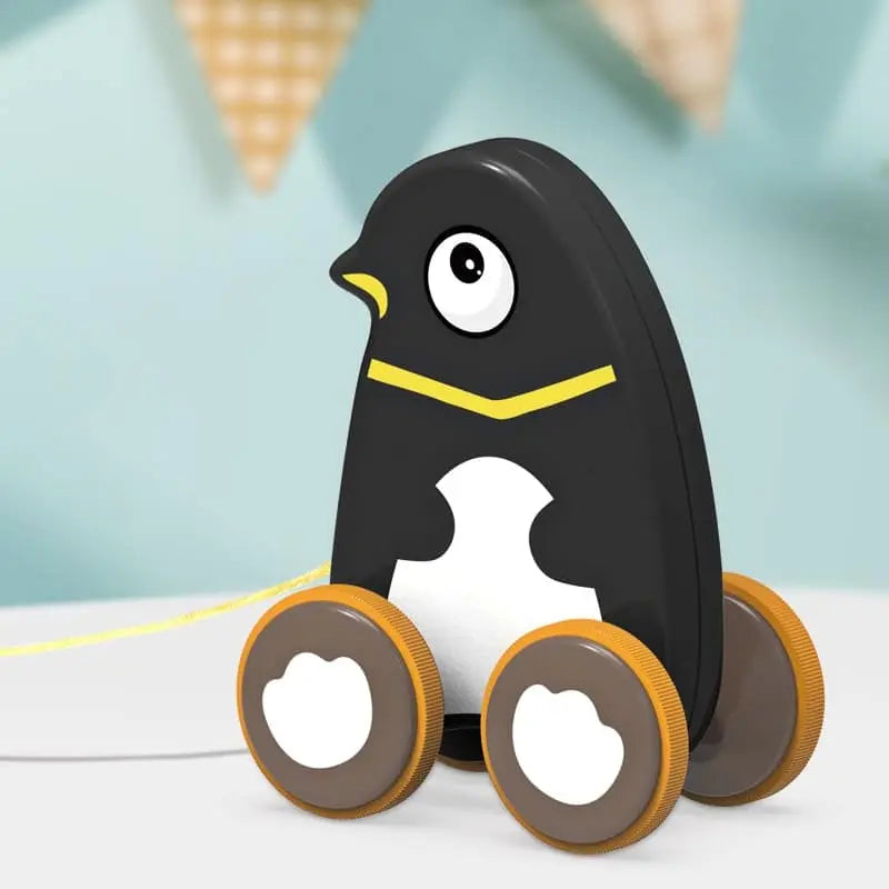 Jeu à tirer - Chien tire une table de jeu avec un ballon devant un pingouin en peluche.