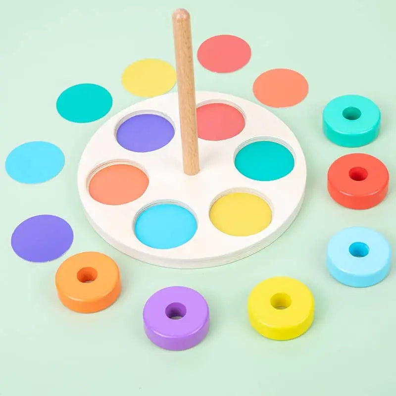 Un jeu de cercles à enfiler en bois avec des cercles colorés et un bâton en bois.