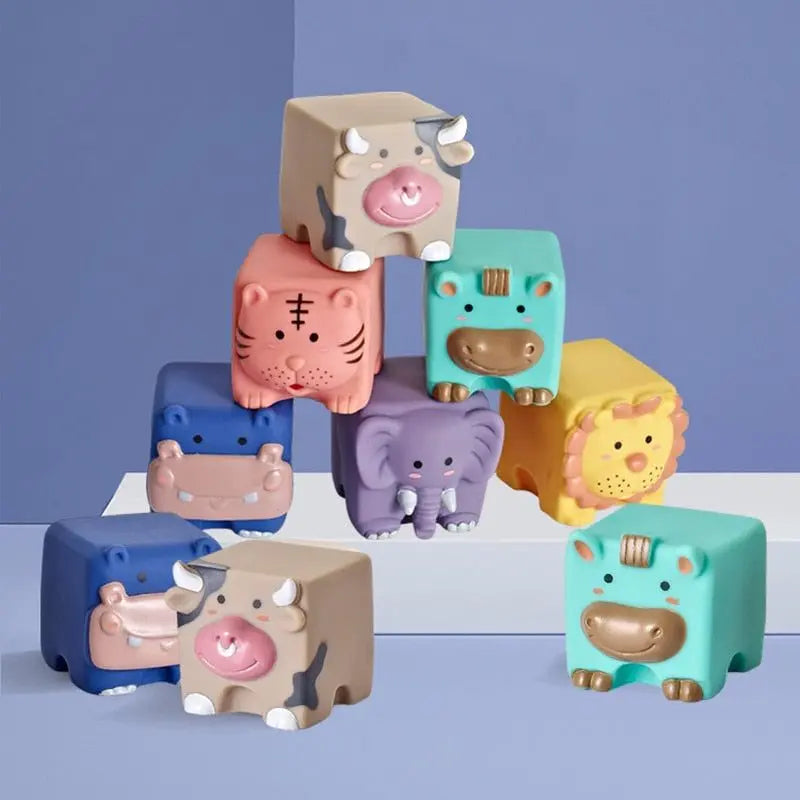 Le Cube d’éveil bébé en silicone – Animaux présente des animaux jouets colorés en forme de cube comme un tigre, une vache, un éléphant, un lion et un hippopotame disposés de manière ludique sur un fond bleu et violet.