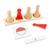 L'ensemble Quilles d'apprentissage des fractions comprend des cônes en bois, un triangle rouge, un cercle avec une moitié rouge et une carte blanche « 1/2 », le tout élégamment présenté sur un fond clair.