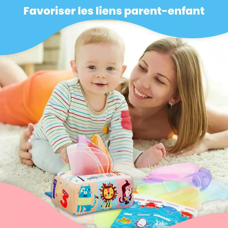Une femme souriante et un bébé jouent par terre avec des mouchoirs en tissu colorés de la Boîte à Mouchoirs Magique et une boîte à jouets. Au-dessus d'eux, on peut lire : "Favoriser les liens parent-enfant.