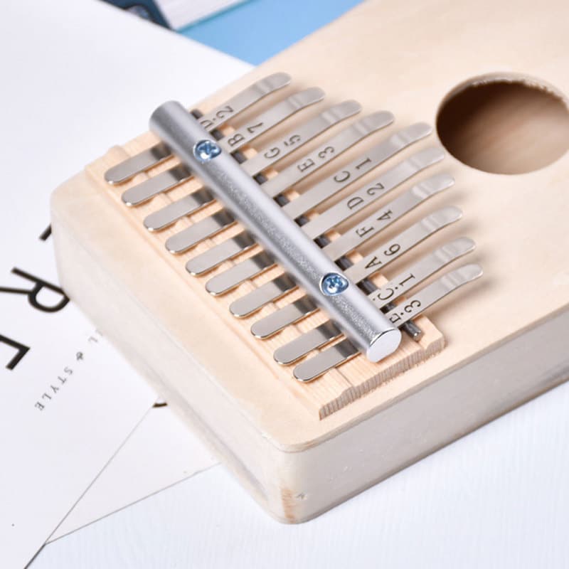 Gros plan d'un kalimba avec des dents métalliques numérotées disposées sur une planche de bois.