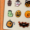 Un souvenir unique composé d'une collection de motifs sur le thème d'Halloween, dont une maison hantée, un fantôme, une citrouille, le pied de Frankenstein et une chauve-souris sur une surface claire. Idéal pour toute occasion pour ajouter une touche personnelle en le transformant en "Puzzle Personnalisé Prénom en Bois" !