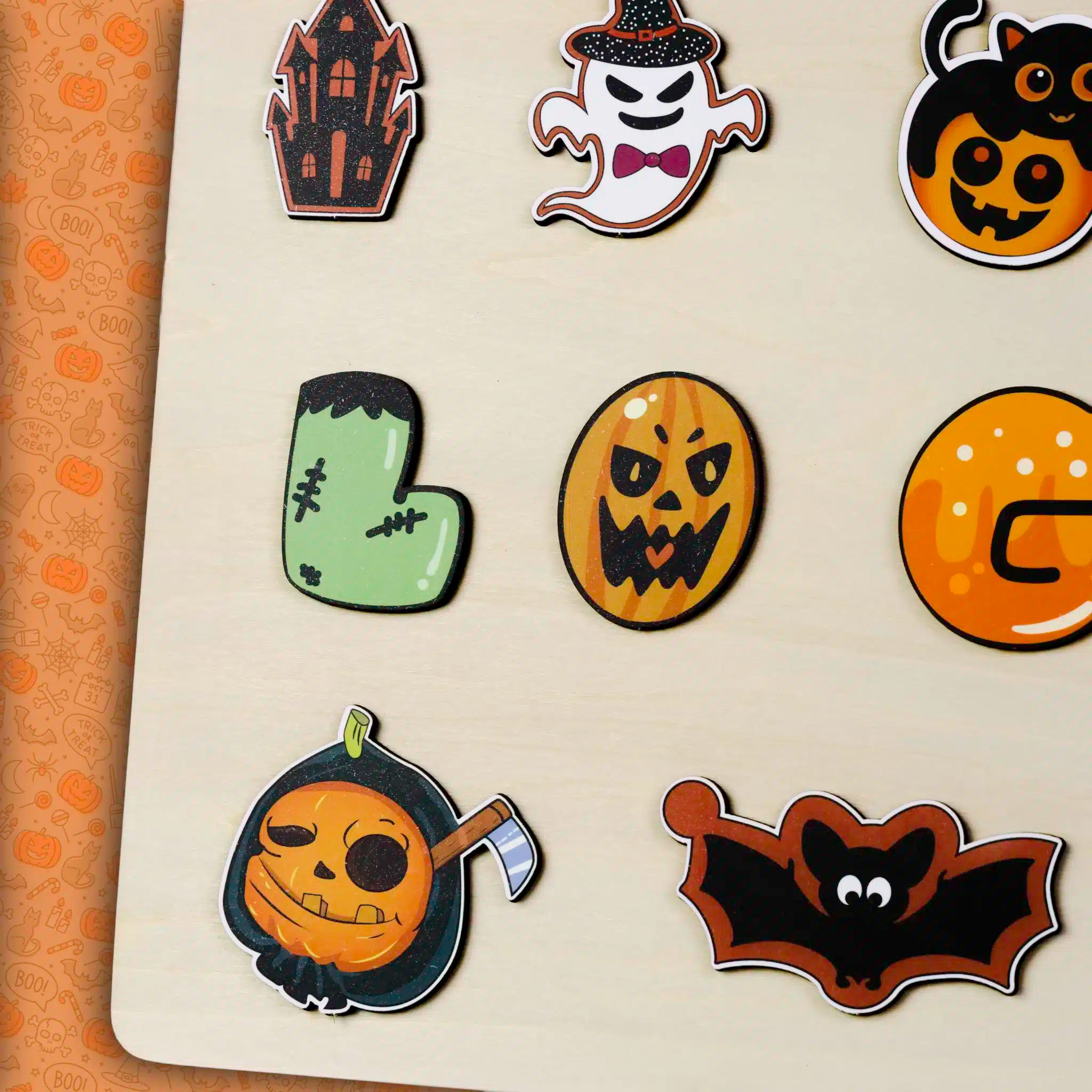 Un souvenir unique composé d'une collection de motifs sur le thème d'Halloween, dont une maison hantée, un fantôme, une citrouille, le pied de Frankenstein et une chauve-souris sur une surface claire. Idéal pour toute occasion pour ajouter une touche personnelle en le transformant en "Puzzle Personnalisé Prénom en Bois" !