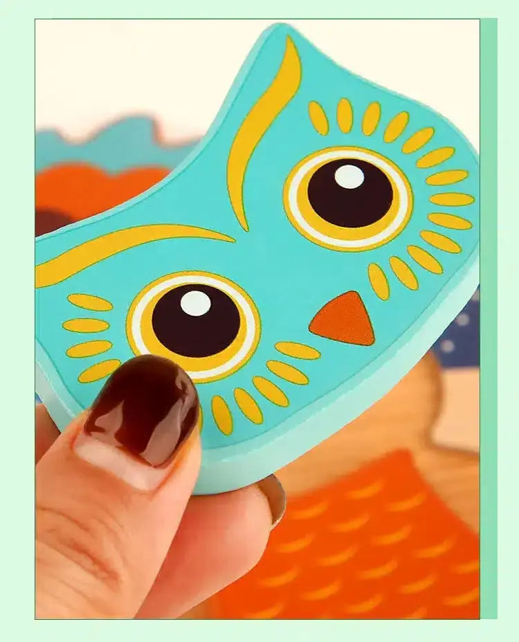 Une personne tenant un jouet puzzle hibou bleu.