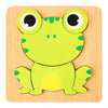 Un puzzle en bois avec une grenouille verte dessus.