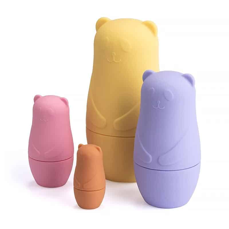 Un ensemble d'ours en plastique assis les uns à côté des autres sur une surface blanche.