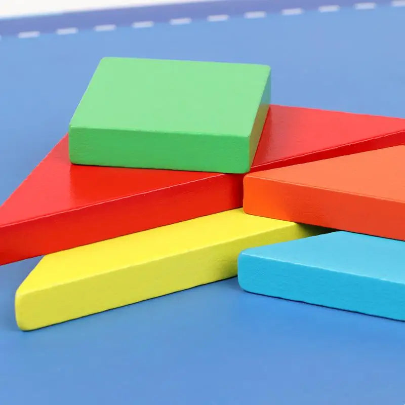 Un ensemble de blocs colorés Livre Puzzle Tangram Magnétique sur une surface bleue.