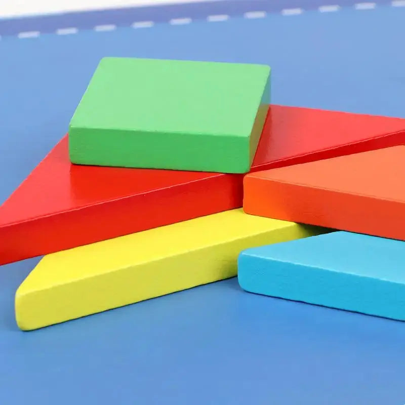 Un ensemble de blocs colorés Livre Puzzle Tangram Magnétique sur une surface bleue.