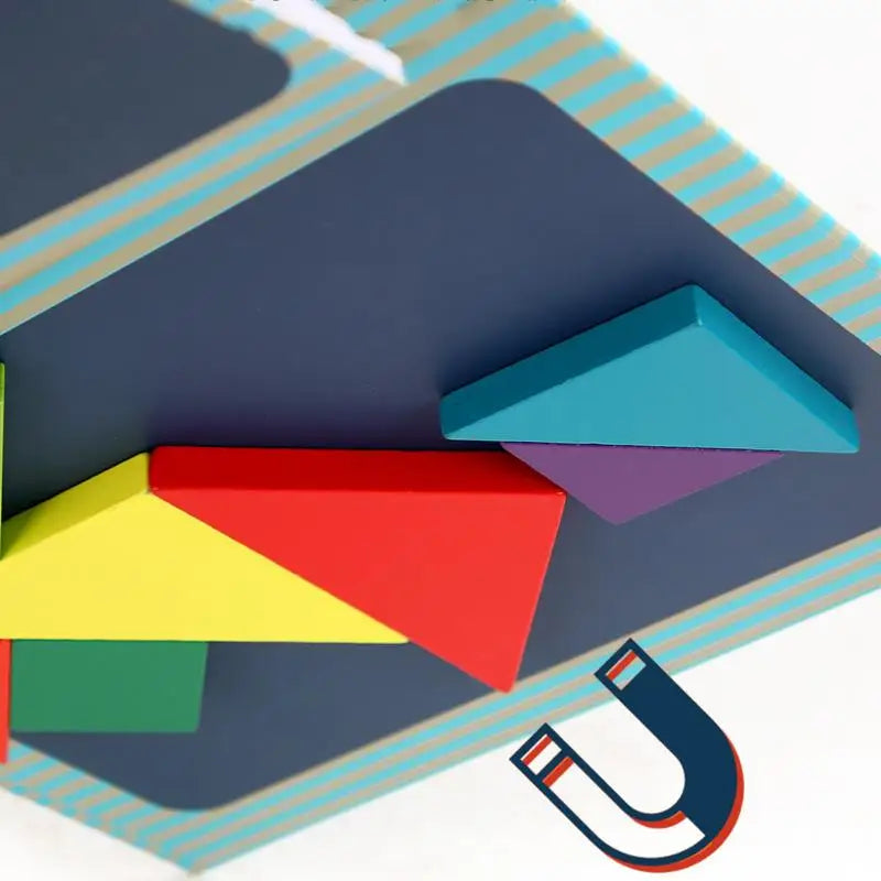 Une boîte surmontée de formes colorées, ressemblant à un Livre Puzzle Tangram Magnétique.