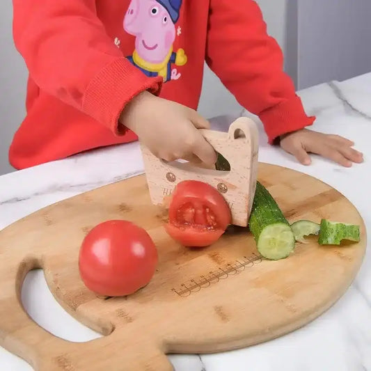 Un enfant coupe des légumes sur une planche à découper en bois.