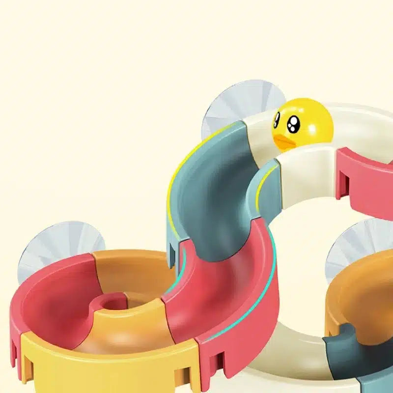 Un Jouet de Bain Tobogan Canard à Ventouse Baignoire coloré avec une boule jaune dedans.