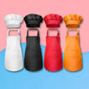 Quatre ensembles Tablier et Toque de Cuisine pour Enfant en blanc, noir, rouge et orange sont disposés en ligne sur un fond rose et bleu.