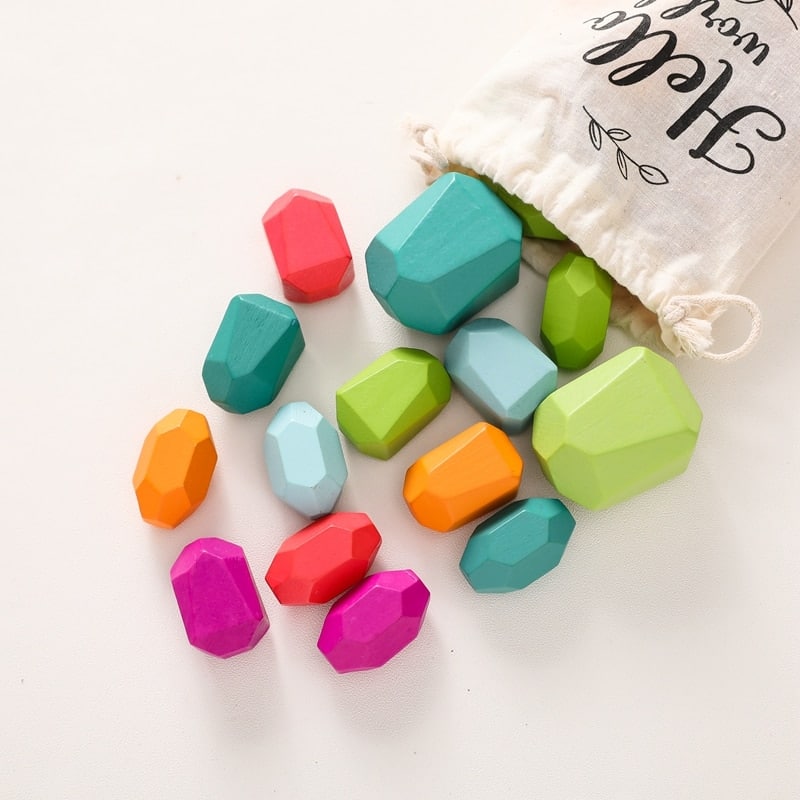 Un sac contenant des blocs de construction en bois en forme de pierres colorées.