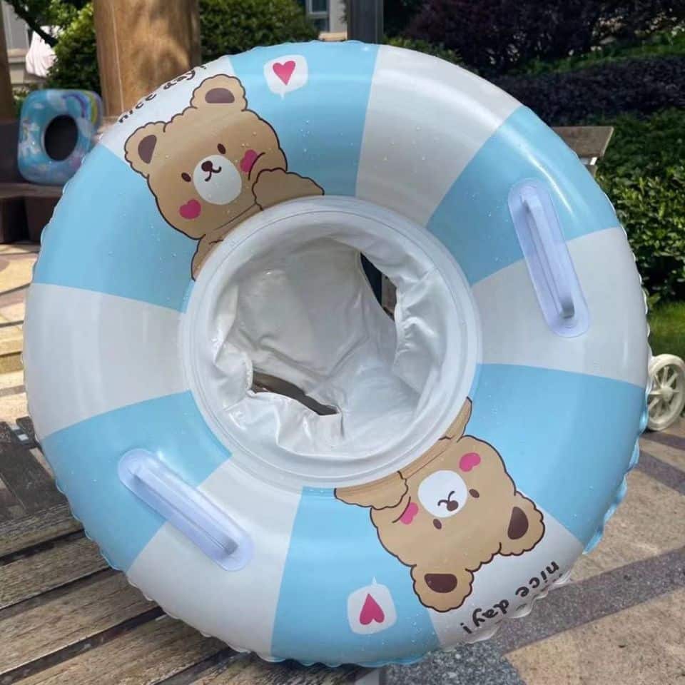 Une Bouée Gonflable 5 ans à 9 ans (20-40 Kg) en forme d'ours en peluche bleu et blanc, adaptée aux enfants de 5 à 9 ans pesant entre 20 et 40 kg.
