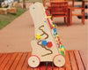 Un Chariot de Marche Bébé - Coloré en bois sur une table en bois.