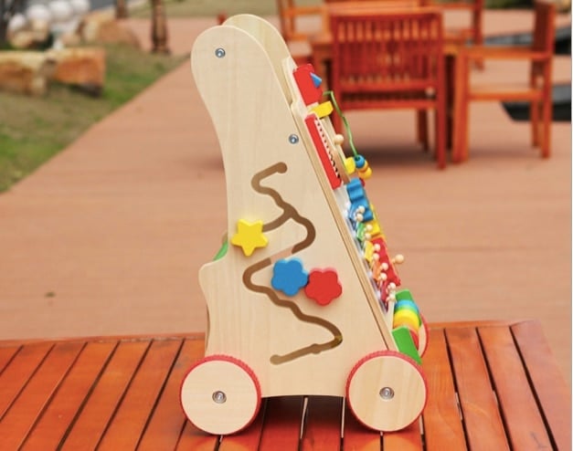 Un Chariot de Marche Bébé - Coloré en bois sur une table en bois.