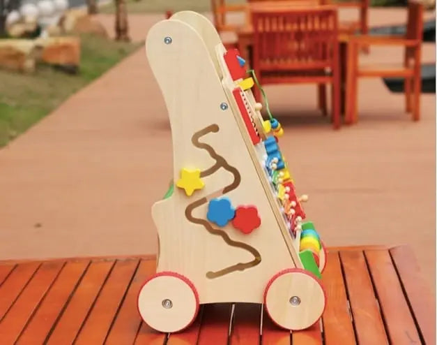 Un Chariot de Marche Bébé - Coloré en bois sur une table en bois.