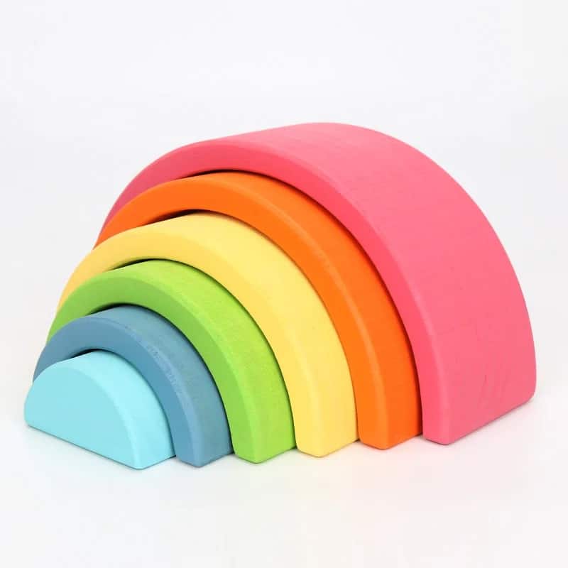 Une pile d'Arc-en-ciel en bois coloré arrangé par taille sur un fond blanc.