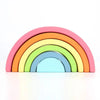 Arc-en-ciel en bois coloré empilé par ordre de taille sur un fond blanc.