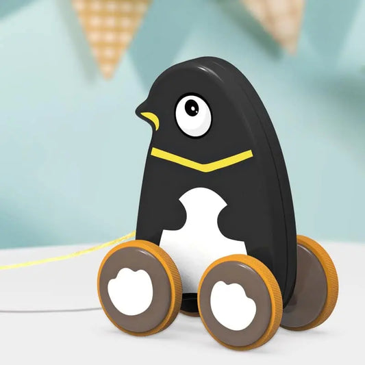Jeu à tirer - Chien tire une table de jeu avec un ballon devant un pingouin en peluche.