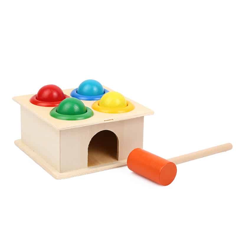 Un Jouet à Marteler 4 Trous de Couleur avec des balles et un marteau.