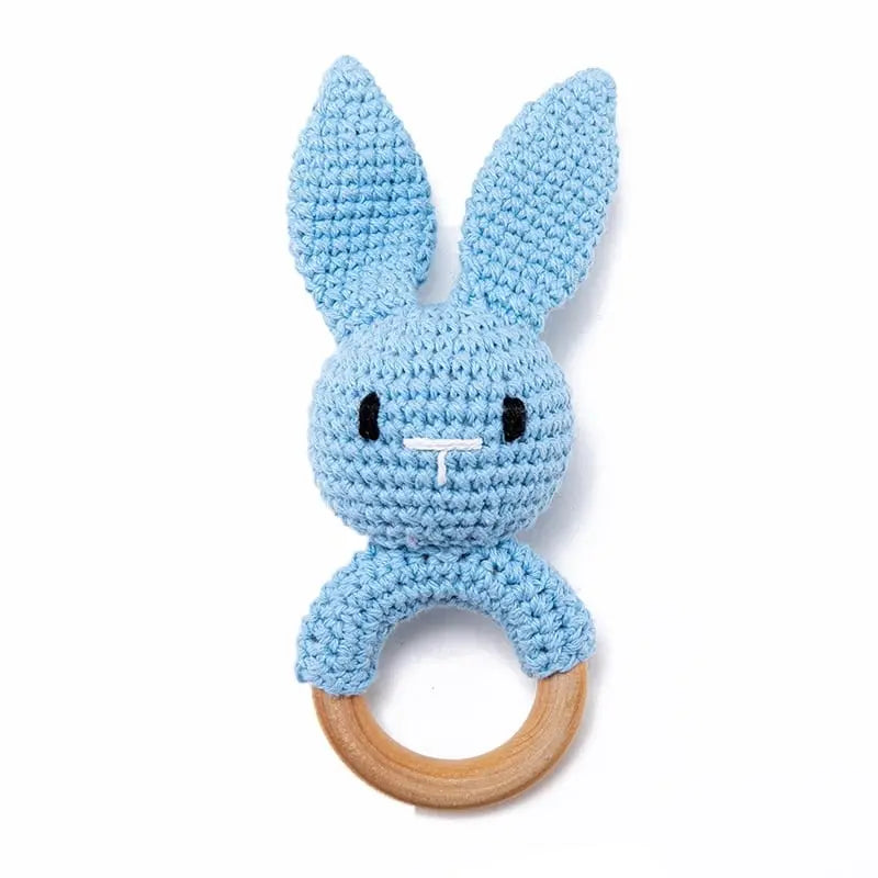 Un Hochet en Bois Lapin Tricoté crocheté sur un fond blanc.