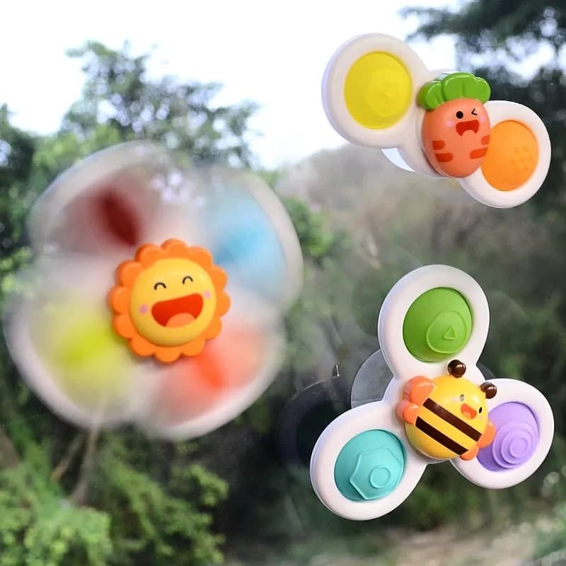 Un groupe coloré de jouets s'affiche dans une fenêtre de voiture, y compris le Spinner de Bain pour Baignoire.