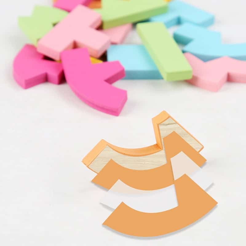 Un Tangram Coeur Coloré en bois coloré disposé sur une surface blanche.