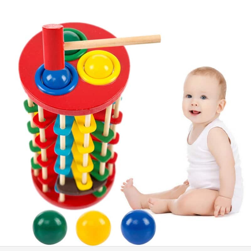 Un bébé joue avec un Tour à 3 Boules à Marteler.