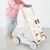 Une petite fille joue avec un Trotteur pousseur bébé - multi-activités - Couleurs pastel.