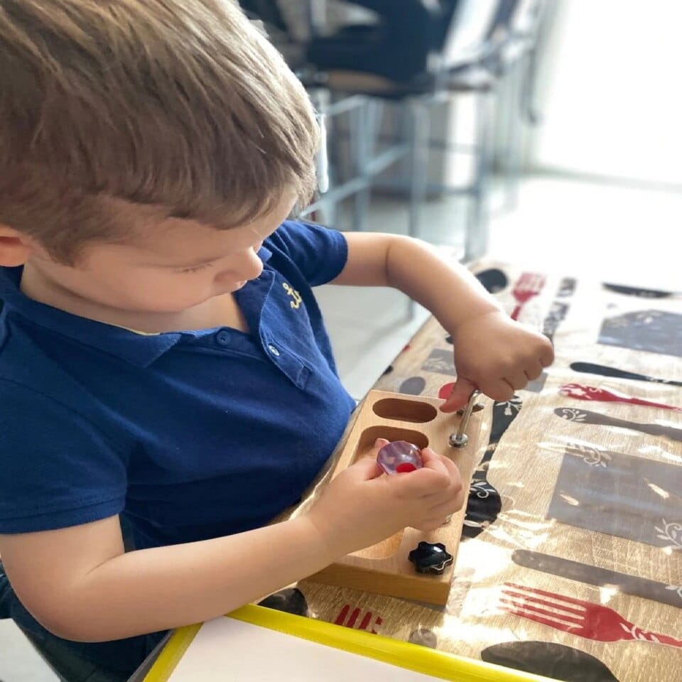 Un jeune garçon jouant avec le Vrai Outils pour Enfants à Visser à une table.
